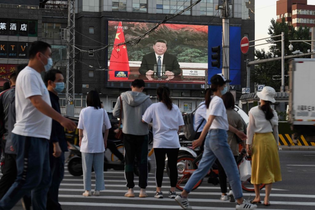 News programs showing China's President Xi Jinping speaking via video to the WHA aired on big screen on Beijing street.